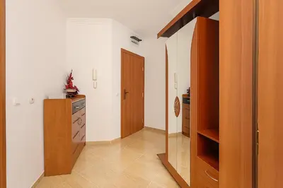 a kitchen with a wooden cabinet and a door at Antonia Seaside Comfort in Sveti Vlas