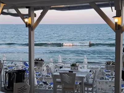 a table on the beach with the ocean in the background at Antonia Seaside Comfort in Sveti Vlas