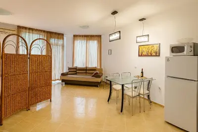 a kitchen and dining room with a table and a refrigerator at Antonia Seaside Comfort in Sveti Vlas