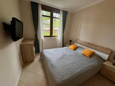 a bedroom with a bed and a tv and a window at Apartment at the Seaside in Sozopol
