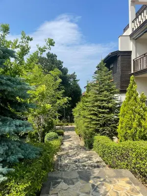 a garden with trees and a stone path at Apartment at the Seaside in Sozopol