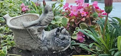a bird statue in a garden with flowers at Victoria guest house in Obzor