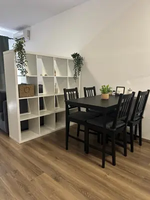 a dining room with a table and chairs and shelves at Relaxing studio in Shartrez in Shkorpilovtsi