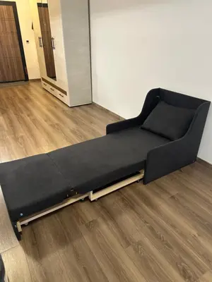 a black bed sitting on the floor in a room at Relaxing studio in Shartrez in Shkorpilovtsi