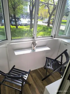 two chairs sitting in a room with two windows at Accommodation apartment MARGARITA in Burgas City