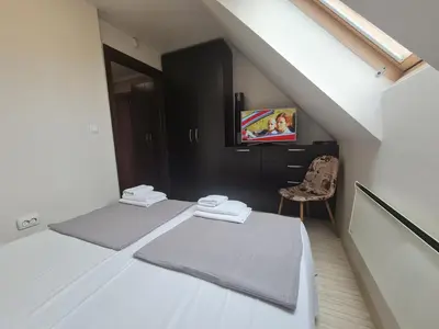 a attic room with two beds and a tv at 
