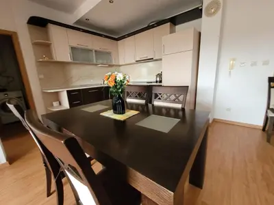 a kitchen with a black table with a vase of flowers at Garden of Eden K 518 in Sveti Vlas