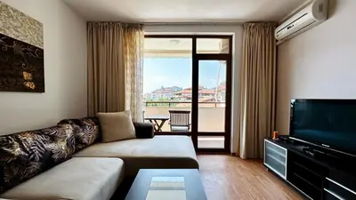 a living room with a couch and a flat screen tv at Garden of Eden K 518 in Sveti Vlas