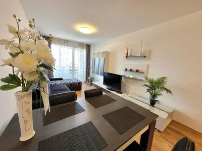 a living room with a couch and a table with flowers at Royal Palm 170 in Sveti Vlas