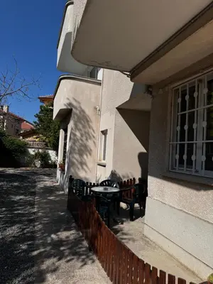 a patio with a table and chairs next to a building at Benadi Guest House in Burgas City