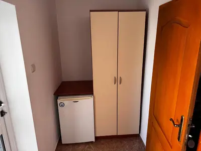a small kitchen with a white cabinet and a refrigerator at Benadi Guest House in Burgas City