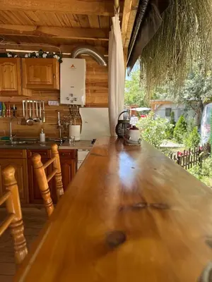 a large wooden table in a kitchen with a window at Каравана Бамбоо in Sozopol