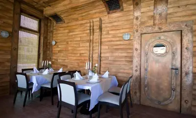 a dining room with tables and chairs and a wooden wall at Appart complex - Egrek 6 in Lozenets