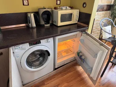 a kitchen with a washing machine and a microwave at Sea View Escape in Burgas City