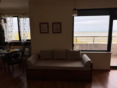 a living room with a couch and a view of the ocean at Sea View Escape in Burgas City