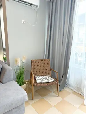a chair sitting in a living room next to a window at Blue Home in Burgas City