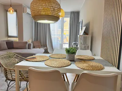 a living room with a white table and chairs at Blue Home in Burgas City