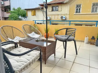 a patio with two chairs and a table on a balcony at Blue Home in Burgas City