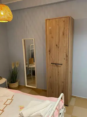 a bedroom with a wooden cabinet and a mirror at Blue Home in Burgas City