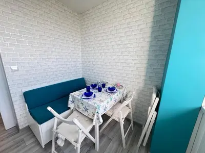 a table with blue chairs and a blue bench at Lazur Sea Home Burgas 2BD in Burgas City