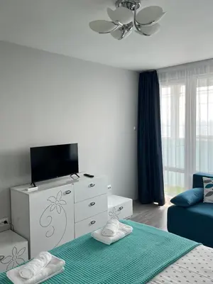a living room with a bed and a tv at Lazur Sea Home Burgas 2BD in Burgas City