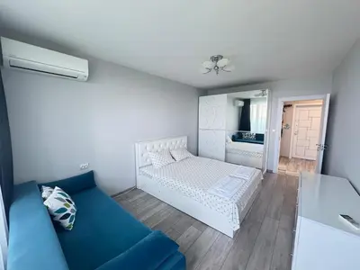 a bedroom with a white bed and a blue couch at Lazur Sea Home Burgas 2BD in Burgas City