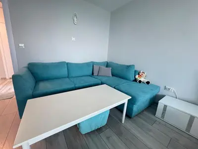 a living room with a blue couch and a table at Lazur Sea Home Burgas 2BD in Burgas City