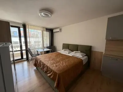 a bedroom with a large bed in a room with a table at Sea Side in Burgas City