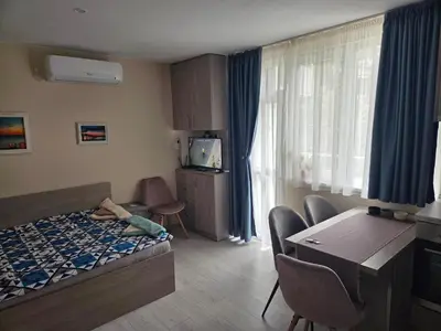 a hotel room with a bed and a table and chairs at Апартамент 9 -Рилска in Burgas City