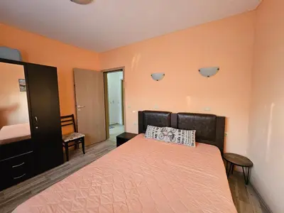 a bedroom with a bed with orange walls at 2BR Sea Sunrise View Apartment Happy Place in Chernomorets