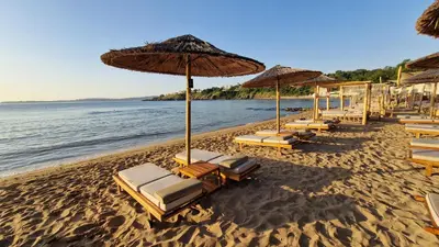 a group of chairs and umbrellas on a beach at 2BR Sea Sunrise View Apartment Happy Place in Chernomorets