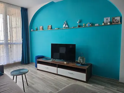 a living room with a flat screen tv on a blue wall at 2BR Sea Sunrise View Apartment Happy Place in Chernomorets