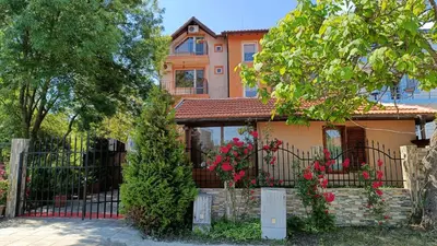 a house with a fence and flowers in front of it at Вила Фернандес in Chernomorets
