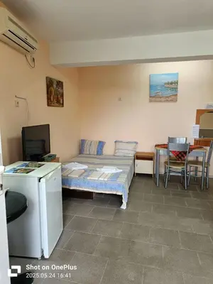 a room with a bed and a table and a television at Вила Фернандес in Chernomorets