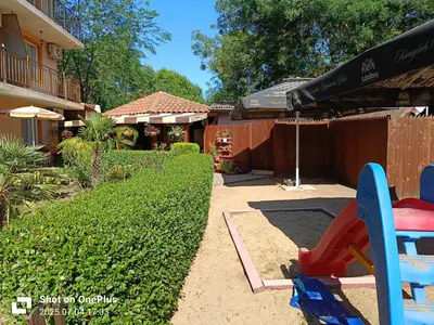 a patio with a table and an umbrella in a yard at Вила Фернандес in Chernomorets