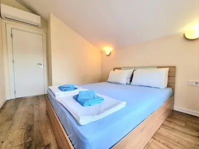 a bedroom with a large blue bed with towels on it at Relax & Spa-House near Therma Numera in Burgas City