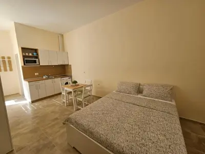 a bedroom with a bed and a small kitchen at Апартаменти Кастро2-Castro Apartments2 in Tsarevo
