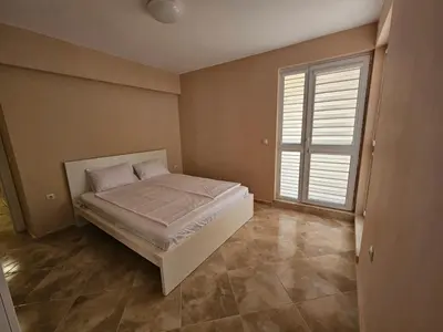 a bedroom with a bed and a large window at Апартаменти Кастро2-Castro Apartments2 in Tsarevo