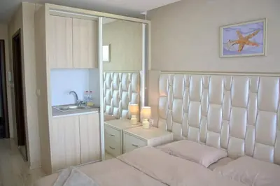 a bedroom with a bed and a sink and a mirror at PARADISO B 410 Studio with SEA VIEW in Nesebar