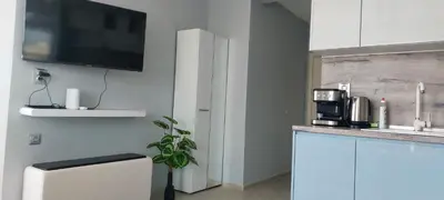 a kitchen with a tv on a wall at Ela, Kedar 5 in Sveti Vlas