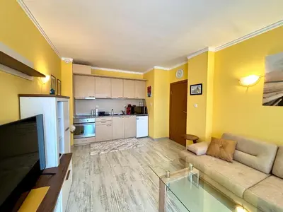 a living room with a couch and a kitchen at Royal Dreams apartments - 2 in Sunny Beach