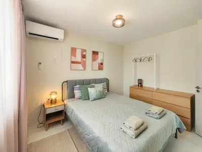 a bedroom with a large bed and a night stand at Marina's Flat in Varna City