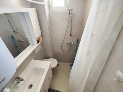 a bathroom with a shower and a toilet and a sink at Marina's Flat in Varna City