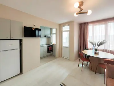 a kitchen and dining room with a table and a refrigerator at Marina's Flat in Varna City