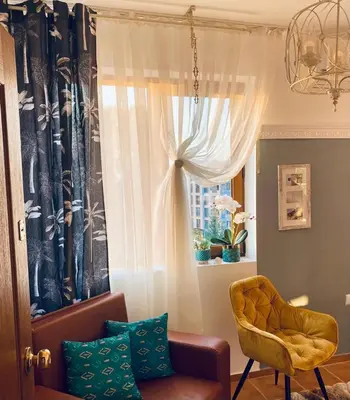 a living room with a chair and a window at Kasandra Apart Hotel in Sunny Beach