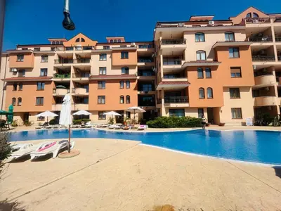 a swimming pool in front of a large apartment building at Kasandra Apart Hotel in Sunny Beach