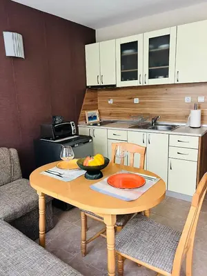 a kitchen with a table with a bowl of fruit on it at GREEN PARADISE apartments in Sveti Vlas