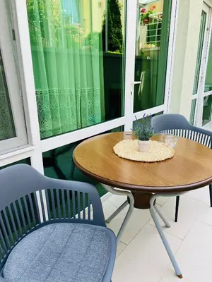 a wooden table and chairs on a porch with a table at GREEN PARADISE apartments in Sveti Vlas