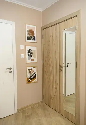 a hallway with a wooden door and pictures on the wall at Stylish Apartment - the Heart of Central Varna by Flat Manаger in Varna City