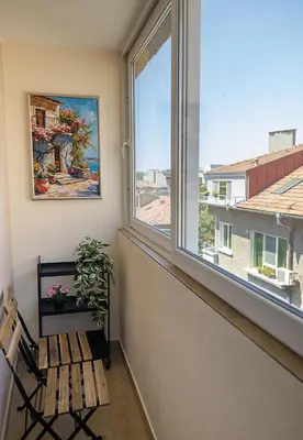 a room with a window with a bench and a plant at Stylish Apartment - the Heart of Central Varna by Flat Manаger in Varna City